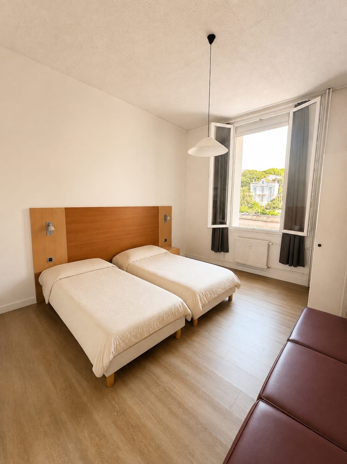 La chambre, ses deux lits accolés et sa fenêtre sur les arbres